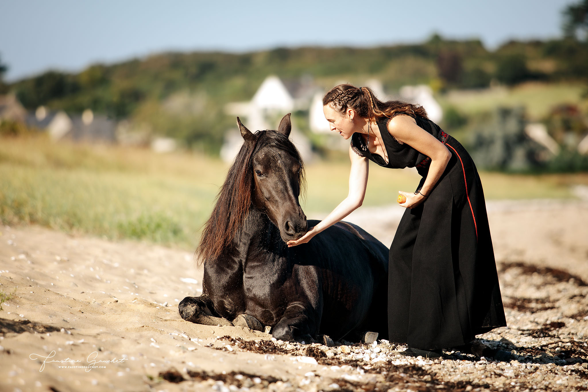 cheval coucher sur la plage avec sa cavalière